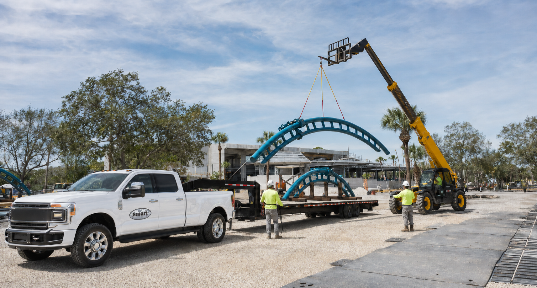 Crew receiving and positioning track sections on an active attraction site